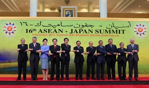 Japan-ASEAN Summit delegates line up and join hands cross-legged in a row (Photo: Cabinet Public Relations Office)