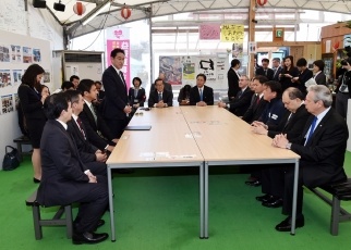 Minister Kishida stands and greets the visitors