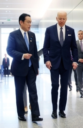 Prime Minsiter Kishida who has a short discussion with President Biden while walking
