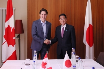 Two leaders who shake hands with each other facing straight at the camera with a smile