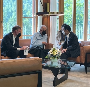 Two leaders who have a talk through their interpreters sitting on sofa and facing with each other