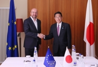 Two leaders who shake hands with each other facing straight at a camera with a smile