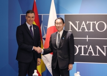 Two leaders who shake hands with each other facing straight at a camera