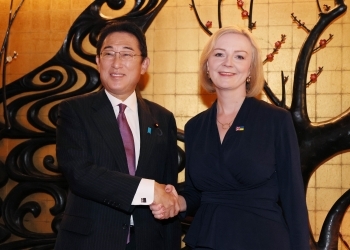 Two leaders who shake hands with each other facing straight at a camera