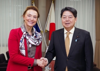 Minister Hayashi and Secretary General Pejčinović Burić who shake hands facing straight at a camera