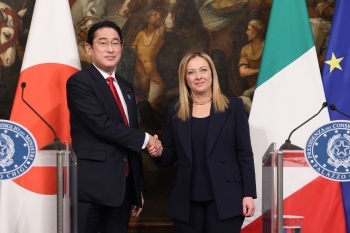 Two leaders who shake hands facing straight at a camera