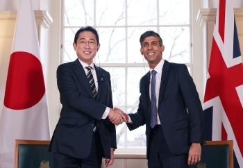 Two leaders who shake hands with a smile facing straight at a camera