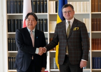 Two Ministers who shake hands facing straight at a camera