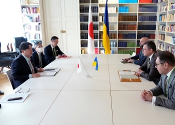 Two Ministers who have a talk after having a seat at a table