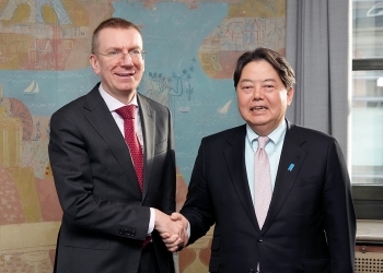 Two Ministers who shake hands with a smile facing straight at a camera