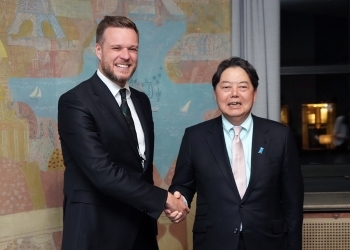 Two Ministers who shake hands with a smile facing straight at a camera