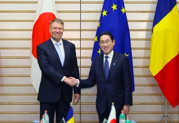 Two leaders who shake hands facing straight at a camera