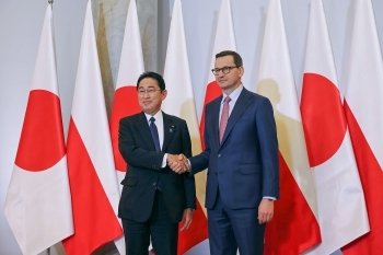 Prime Minister Kishida and Prime Minister Morawiecki who shake hands facing straight at a camera