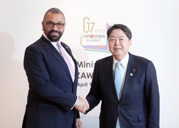 Two Ministers who shake hands facing straight at a camera