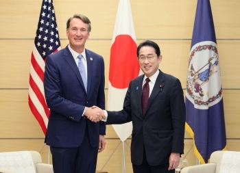 Prime Minister Kishida and Governor Youngkin who shake hands facing straight at a camera