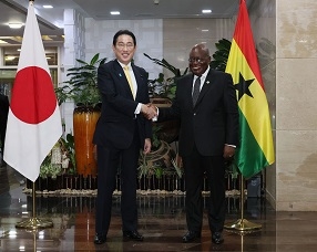 Two leaders who shake hands with a smile facing straight at a camera