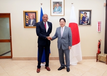 Two Ministers who shake hands facing straight at a camera