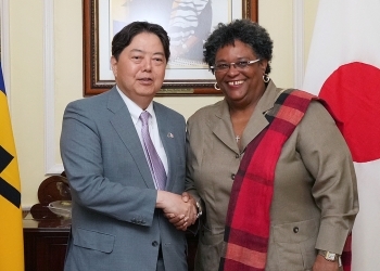 Minister Hayashi and Prime Minister Mottley who shake hands facing straight at a camera