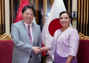 Minister Hayashi and President Boluarte who shake hands with a smile facing straight at a camera