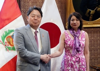 Two Ministers who shake hands facing straight at a camera