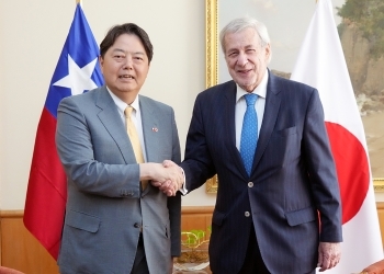 Two Ministers who shake hands with a smile facing straight at a camera