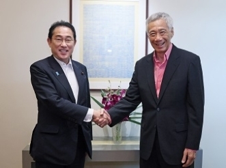Two leaders who shake hands with a smile facing straight at a camera