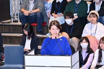 Mrs. Kishida who makes a speech standing behind a lectern