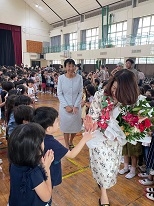 Mrs.Kishida who responds with low touch to students of the kindergarten department receiving a welcome from them