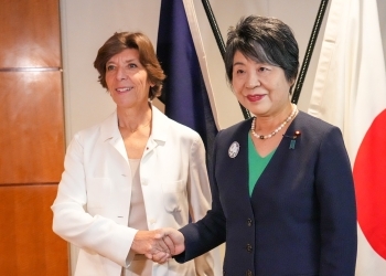 Two Ministers who shake hands facing straight at a camera