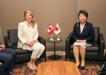 A commemorative photo of Two Ministers facing straight at a camera after having a seat