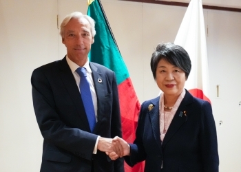 Two Ministers who shake hands facing straight at a camera