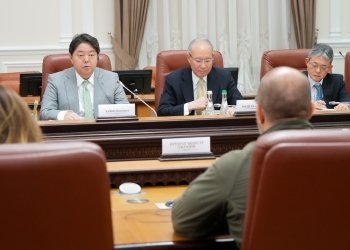 Minister Hayashi who exchanges opinions with Prime Minister Shmyhal of Ukraine after having a seat at a table facing straight at a camera