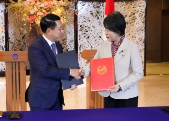 Two Ministers who shake hands facing each other after exchanging signed notes