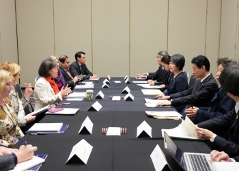 Ministers of the two countries who have a talk after having a seat at a table