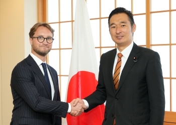 Both sides who shake hands facing straight at a camera