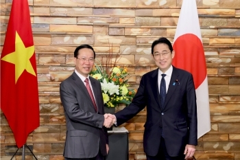 Two leaders who shake hands with a smile facing straight at a camera