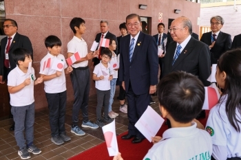 Prime Minister Mr. Ishiba is passing before children of Nikkei people in Peru, shaking Hinomaru and Peru national flag