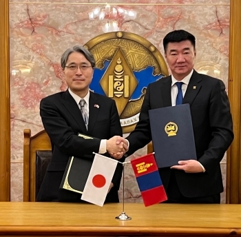 Ambassador IGAWAHARA shaking hands with Minister of Defence of Mongolia BYAMBATSOGT with the Agreement in their hands