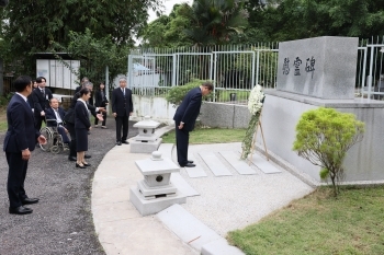 Prime Minister Ishiba bowing in front of a grave in the Japan cemetery
