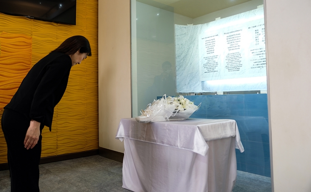 Ms. IKUINA praying silently for the victims to the cenotaph