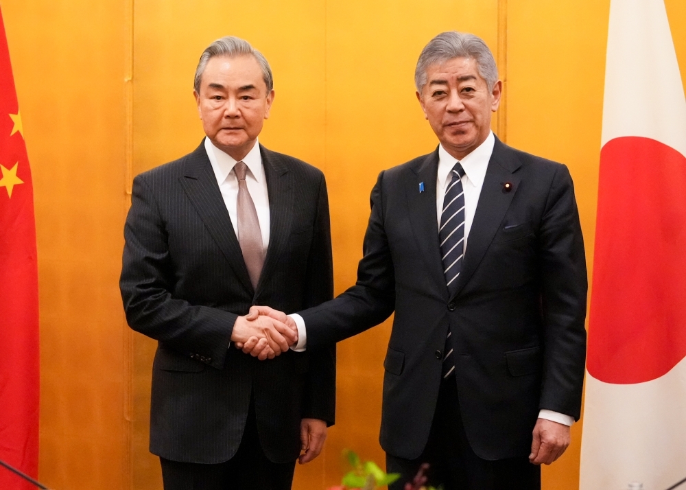 Foreign Minister Iwaya shaking hands with Foreign Minister Wang Yi