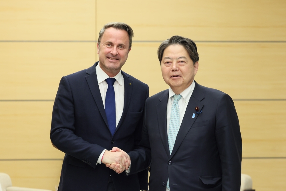 Chief Cabinet Secretary Hayashi shaking hands with Deputy Prime Minister and Foreign Minister Bettel