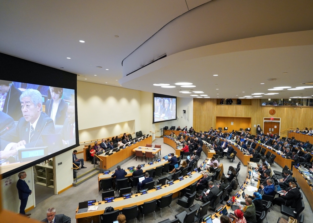 Foreign Miniser Iwaya delivering his speech is on the enormous monitor, and participants in the conference room