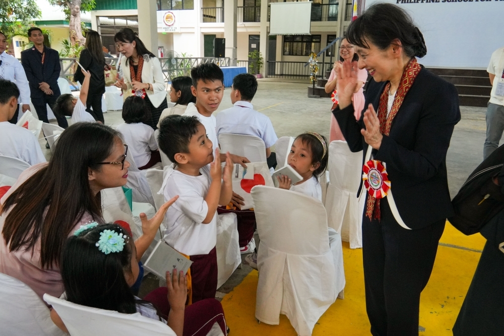 Mrs. Ishiba using sign language with children