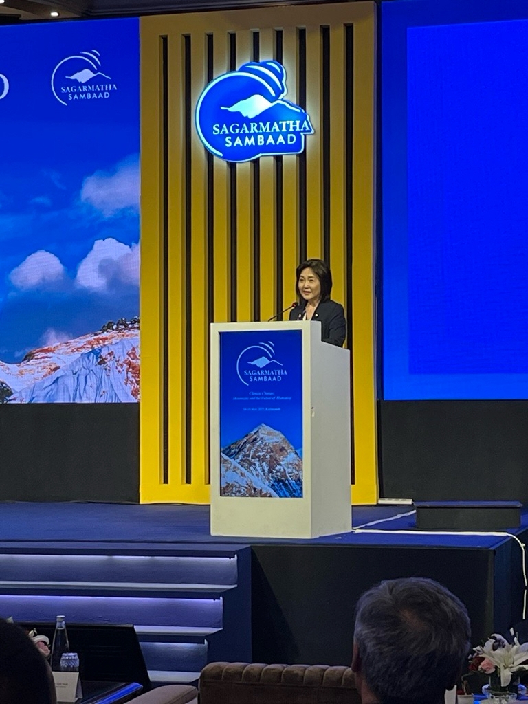 Ms. IKUINA, Parliamentary Vice-Minister is delivering her statement on the stage