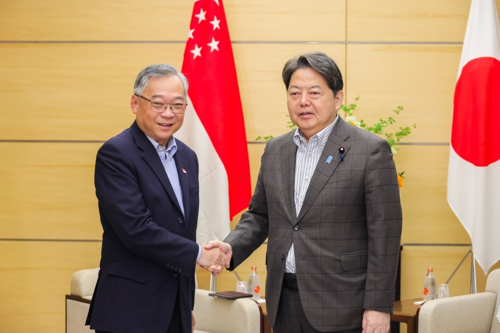 Chief Cabinet Secretary Hayashi shaking hands with Deputy Prime Minister and Minister of Trade and Industry Gan