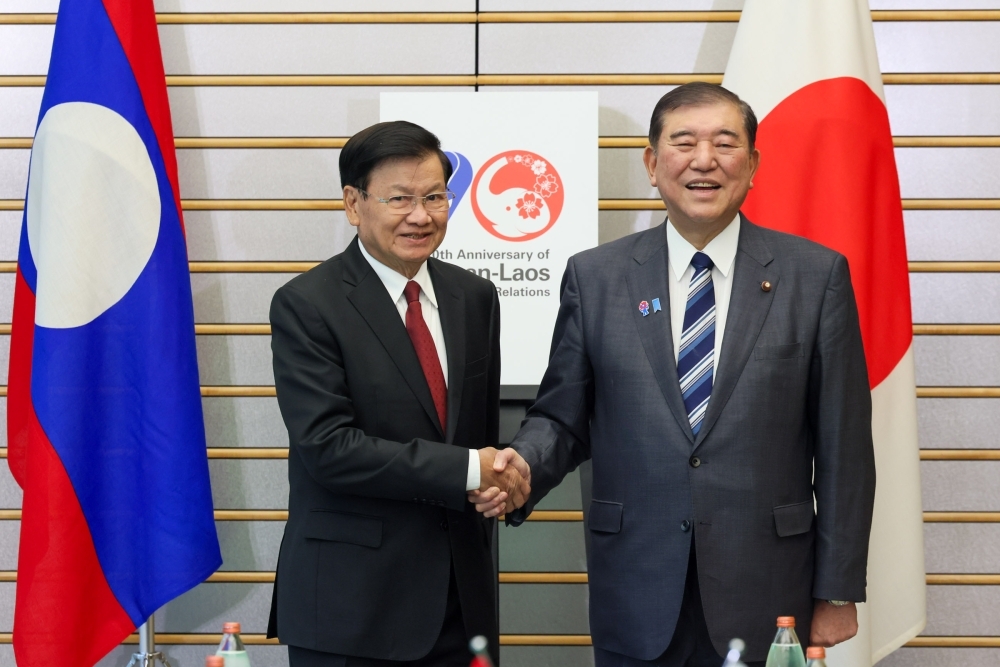 Prime Minister Ishiba is shaking hands with Dr. Thongloun SISOULITH, President of the Lao People’s Democratic Republic. Backside, board of 70th anniversary of two countries