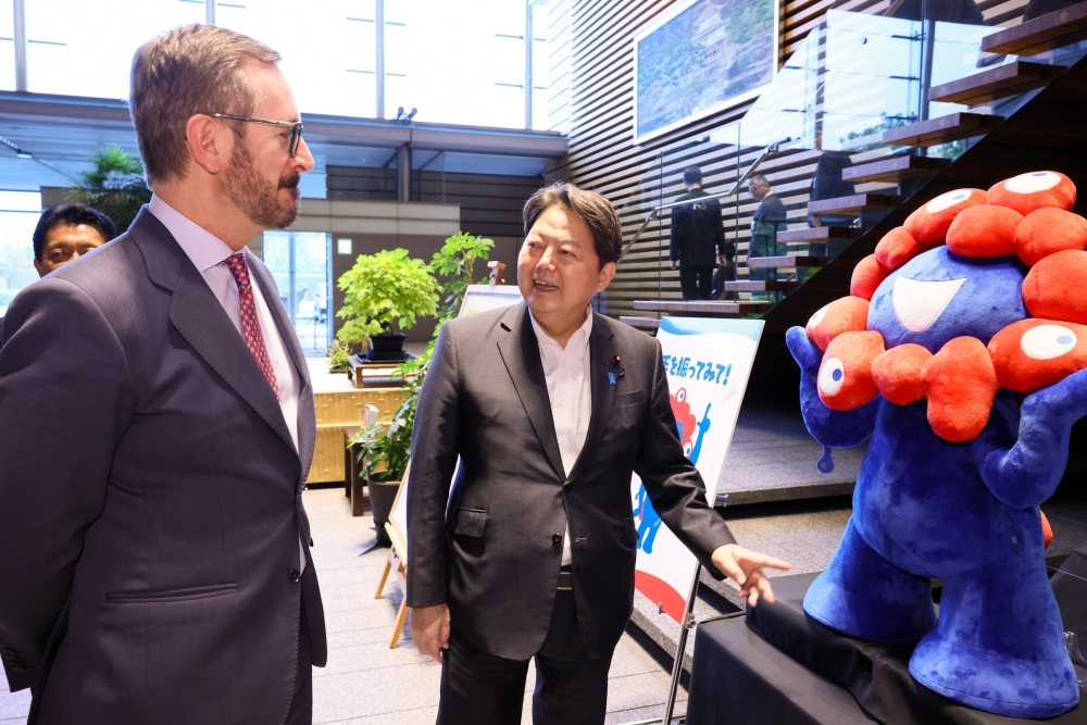 Mr. HAYASHI, Chief Cabinet Secretary is showing the Expo Character, MYAKU-MYAKU, to Mr. Javier MAROTO ARANZÁBAL, First Vice-president of Senate of Spain