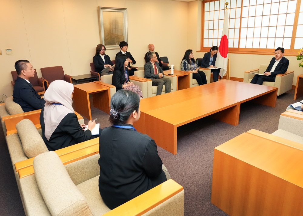 Group photo, Parliamentary Vice-Minister Matsumoto is talking with the delegation of the ASEAN Secretariat officials