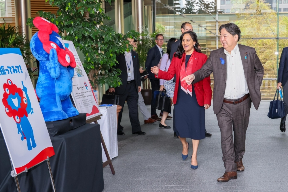 Mr. HAYASHI, Chief Cabinet Secretary is showing and explaining the Myakmyak, the Character of the Osaka Expo exhibition